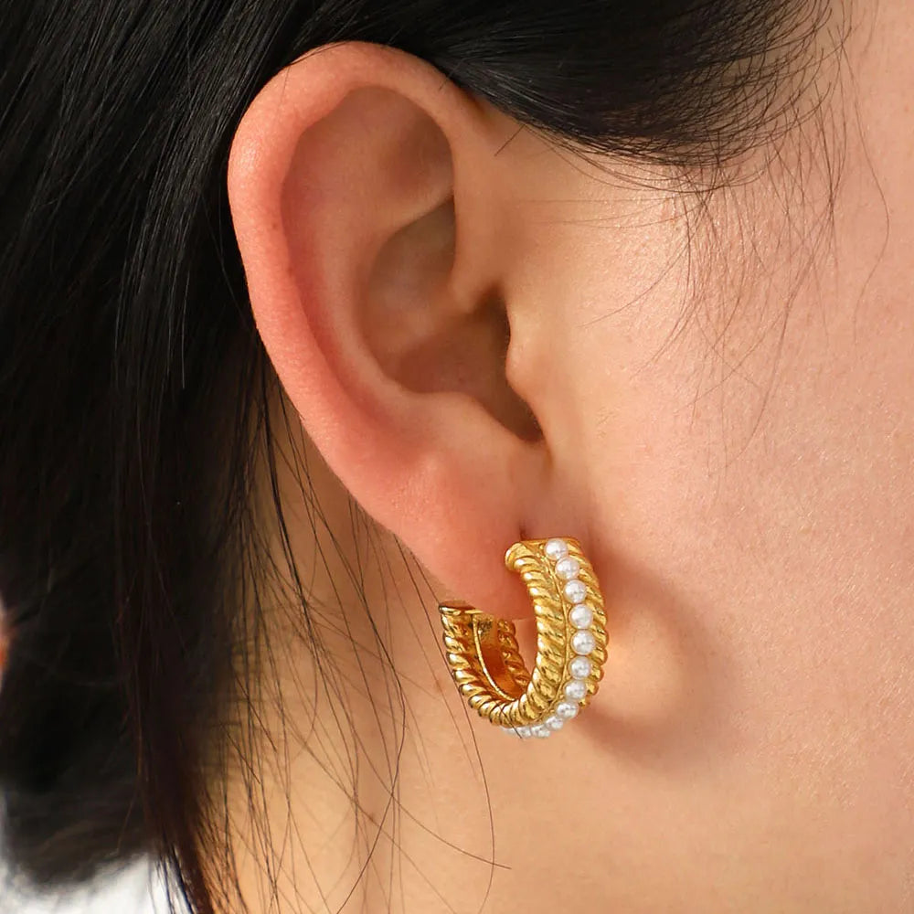 Woman wearing gold stainless steel pearl C-hoop earrings, 18K gold-plated hypoallergenic hoops for everyday style.