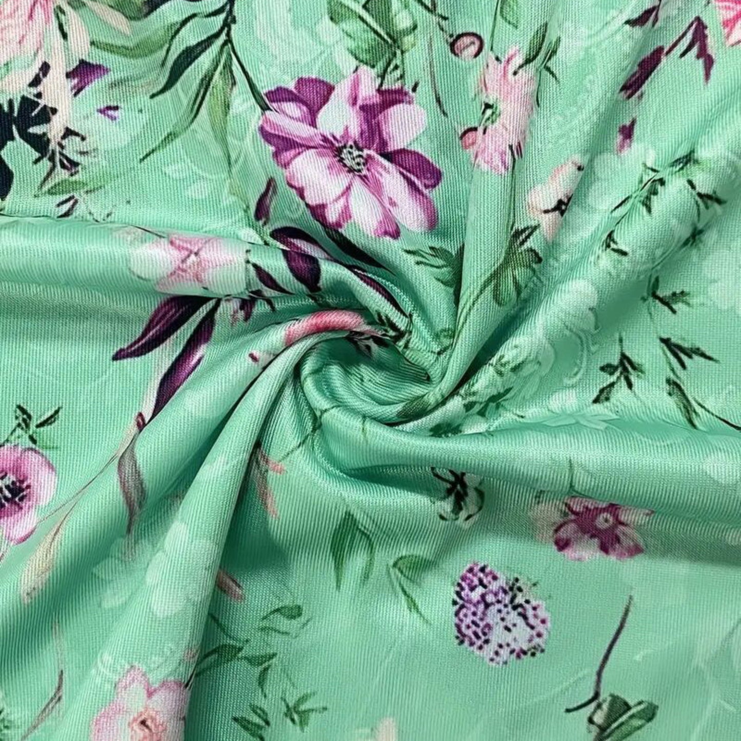 Floral fabric with pink and purple flowers on a green background