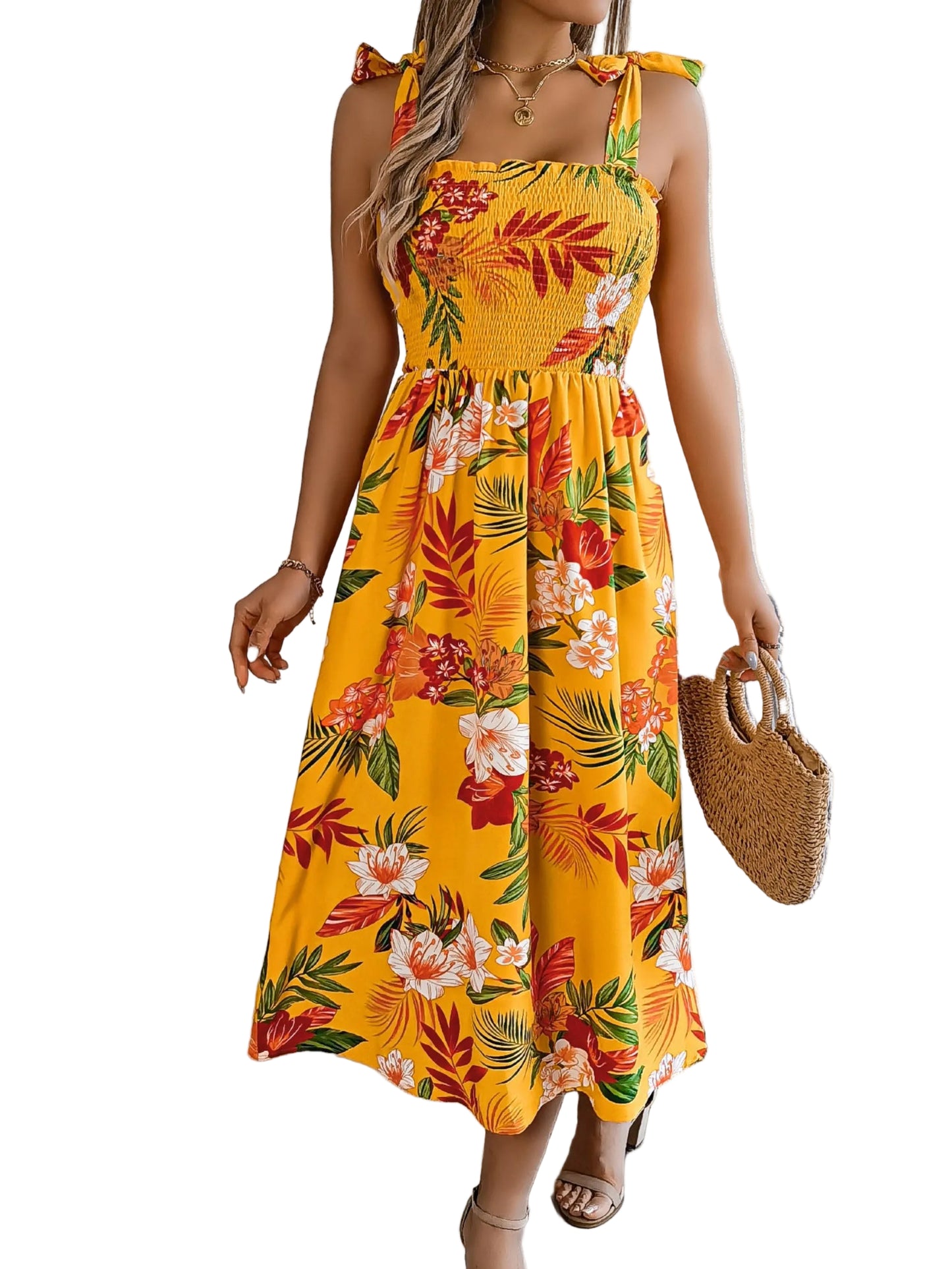 Woman wearing a yellow floral dress in a bright room with a plant and chair.