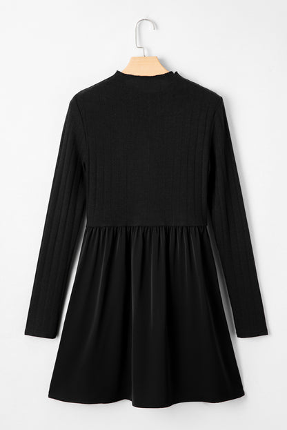 Black long-sleeve skater dress displayed on a wooden hanger against a white background.”