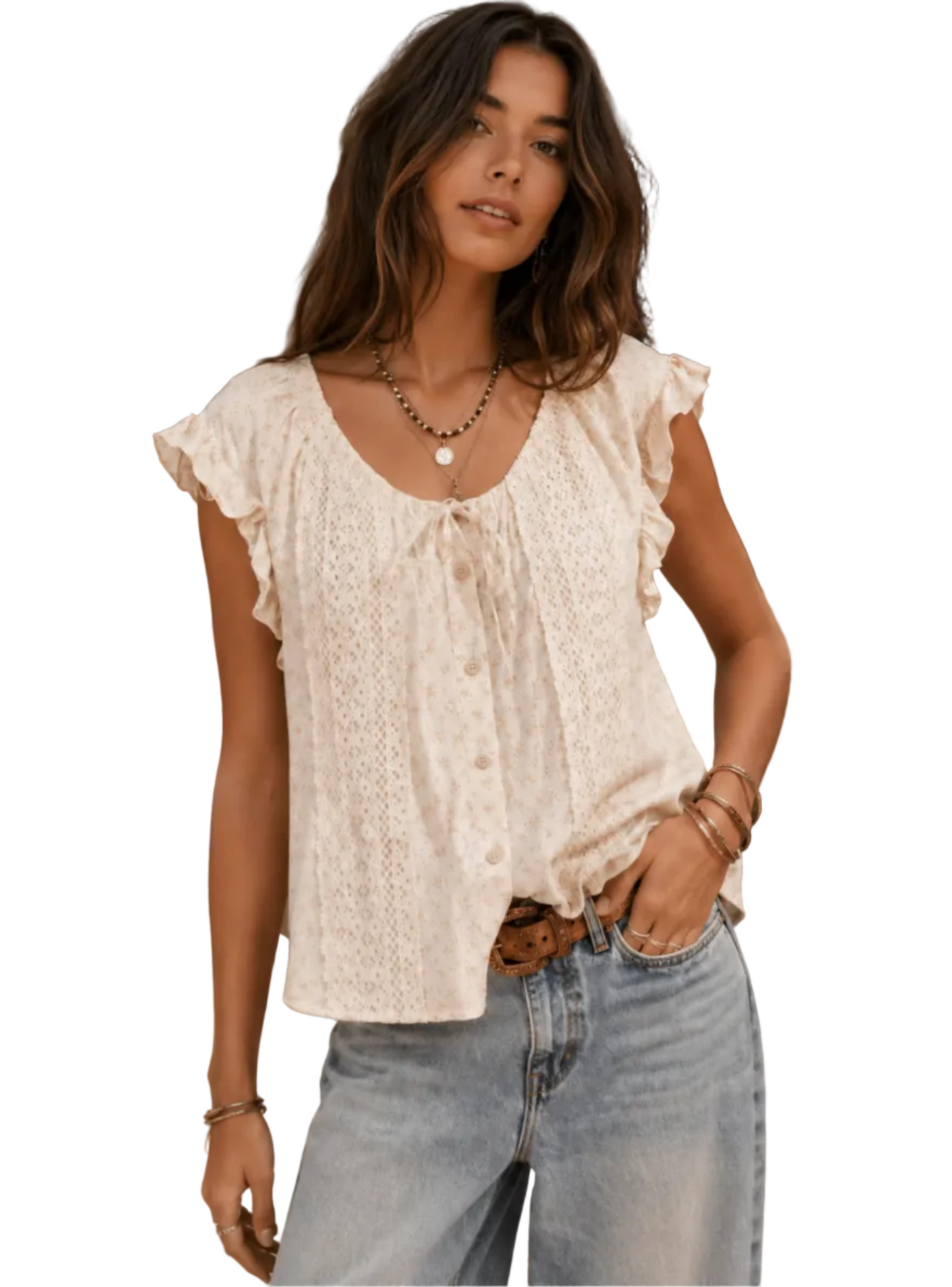 A woman wearing a cream-colored lace blouse with ruffle sleeves and a tie-neck detail, paired with light-wash blue jeans in an outdoor courtyard setting.