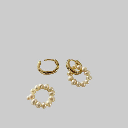 Gold hoop earrings with pearl accents on a white background