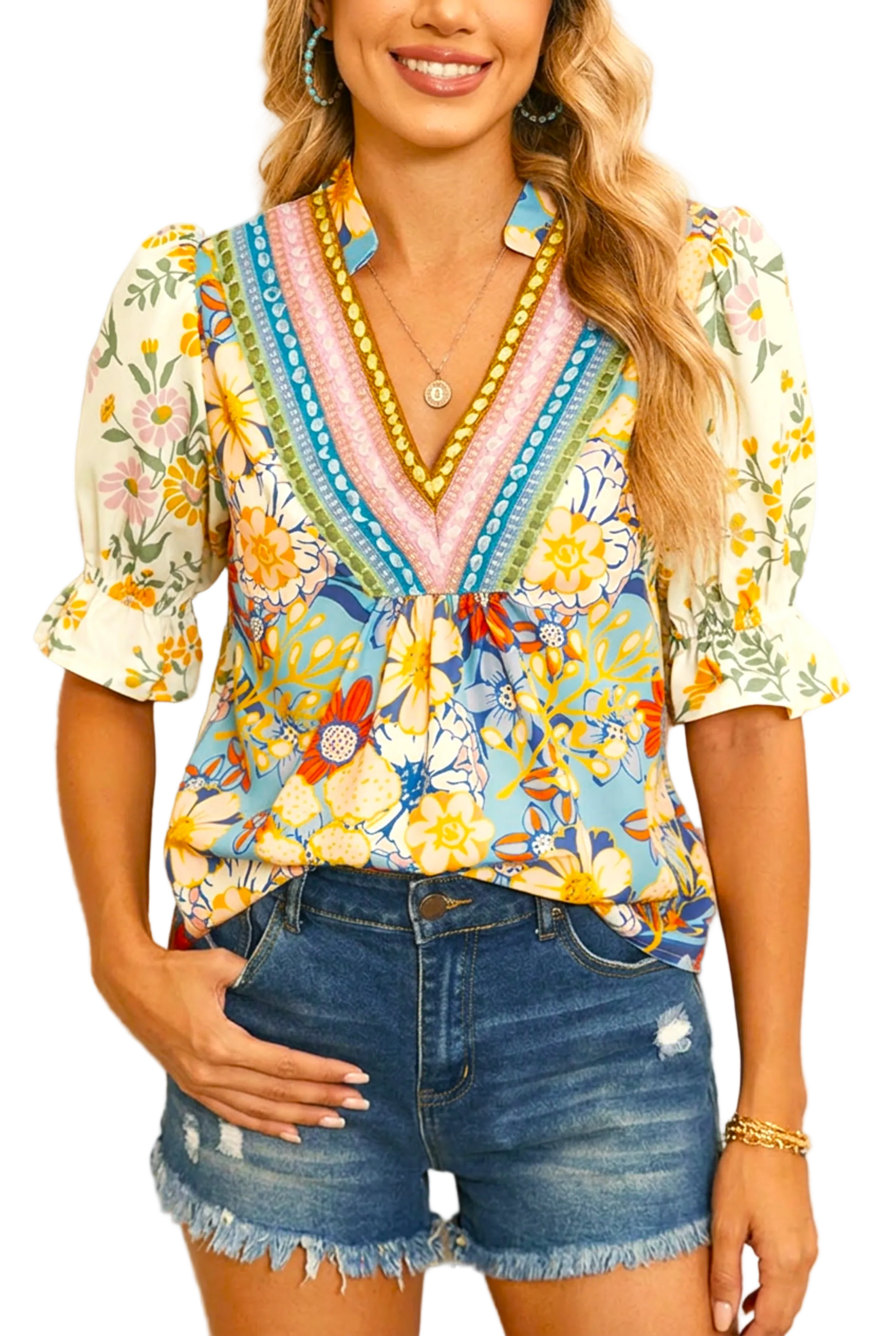 Woman wearing a colorful floral blouse and denim shorts against a neutral background