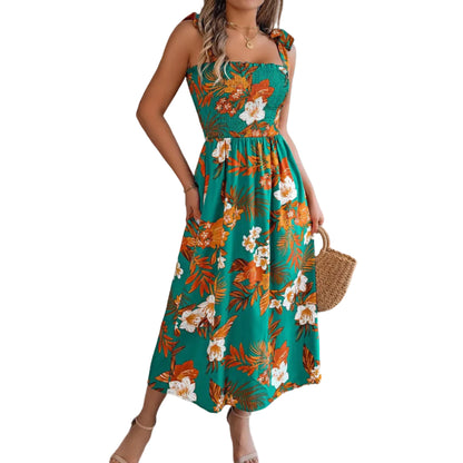 Woman wearing a floral dress in a room with a plant and sofa.